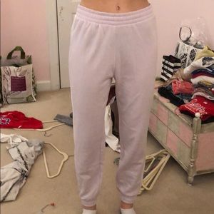 Purple sweatpants with white stripes on sides